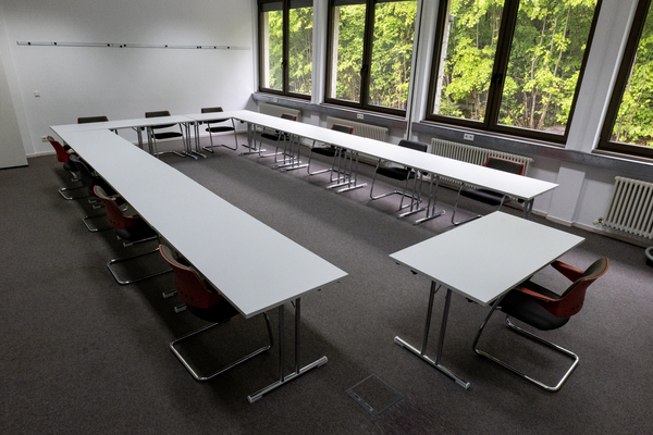 Blick in einen Seminarraum. U-förmige Bestuhlung. Blick nach draußen.